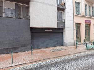 a building with a garage door on a street at Feel Home DeLuxe CORVIN # FREE PARKING # AC # Elevator in Budapest