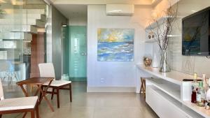ein Esszimmer mit einem Tisch und einem Gemälde an der Wand in der Unterkunft Refúgio Pé na Areia com 4 quartos em Ilhéus - Condomínio Perfeito para Família! in Ilhéus