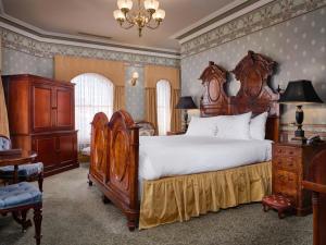 a large bedroom with a large bed and a chandelier at Craig's Royal Hotel in Ballarat