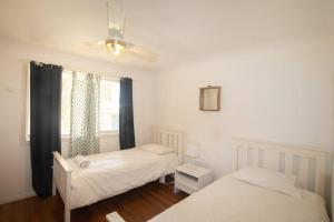 Un pat sau paturi într-o cameră la Palm Beach House - sleeps 10 - spacious
