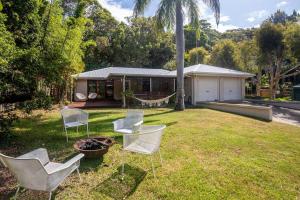 a yard with white chairs and a house at Palm Beach House - sleeps 10 - spacious in Point Lookout