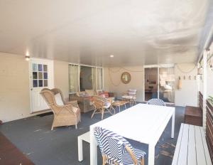 a patio with a table and chairs and a living room at Palm Beach House - sleeps 10 - spacious in Point Lookout