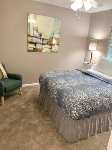 1 dormitorio con 1 cama y 1 silla verde en E. Turkeyfoot Whole House, en Akron