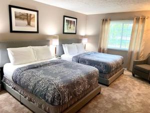 a hotel room with two beds and a chair at E. Turkeyfoot Whole House in Akron