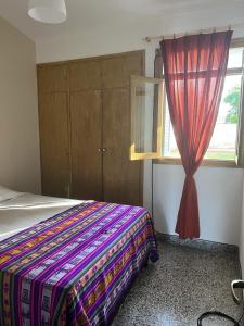 1 dormitorio con 1 cama con cortina y ventana en ARMONIA en Salta