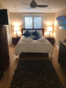 a bedroom with a bed with blue pillows and two lamps at Private bedroom & den suite with shared pool & tropical garden in Fort Lauderdale