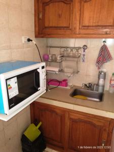 a kitchen with a microwave and a sink at Monoambiente para 2 personas en Neuquen in Neuquén