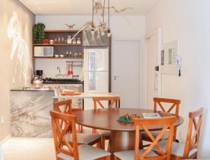 a kitchen and dining room with a wooden table and chairs at Apto temático Dinossauros in Pomerode
