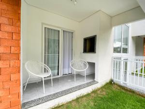 two chairs sitting on the balcony of a house at Apto temático Dinossauros in Pomerode