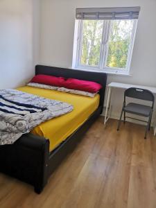 a bedroom with a bed and a chair and a window at Langley Haven - 3 BR House in Kent