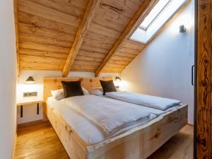un grande letto in una camera con soffitto in legno di AlmApARTment Mauterndorf Pichl 7-4 a Mauterndorf