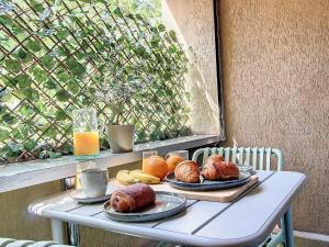 a table with two plates of food and a window at La Pitcholine : Superbe studio au Vieux-Port in Marseille