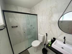 a bathroom with a shower and a toilet and a sink at Edifício Creta in São Luís