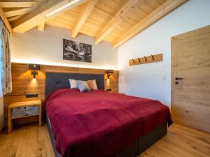 Chalet Pettneu am Arlberg - Top 3 في بيتنيو آم أرلبرغ: غرفة نوم بسرير كبير مع بطانية حمراء