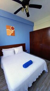 a white bed with a blue pillow on top of it at MODERNO DEPARTAMENTO EN EL CENTRO in Tulum +18 photos