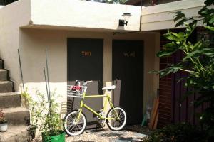 uma bicicleta amarela estacionada em frente a duas portas em TTOL LANG Cottage Jeonju Hanok Village em Jeonju