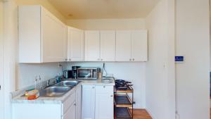 una cocina con armarios blancos y fregadero en Comfy Guesthouse in Yelm en Yelm