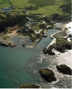 an aerial view of a body of water with rocks at Cosy 3 bedroom apartment in central Portrush with sea views in Portrush