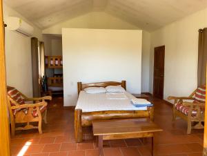 een slaapkamer met een bed en 2 stoelen bij Casa Iguana in Las Tablas