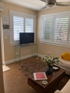 a living room with a tv and a coffee table at Private bedroom & den suite with shared pool & tropical garden in Fort Lauderdale