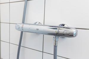 une pomme de douche sur le côté d'une paroi dans l'établissement Charming Retreat Cozy Family Apartment-20B, à Delft