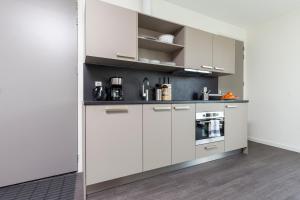 uma cozinha branca com armários e electrodomésticos brancos em City Center Family Apartment Balcony open View Delft em Delft