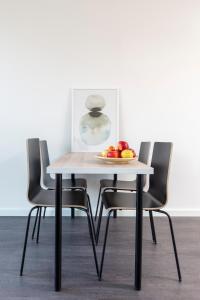 - une table et des chaises avec un bol de fruits dans l'établissement Charming Retreat Cozy Family Apartment-20B, à Delft 8 autres photos