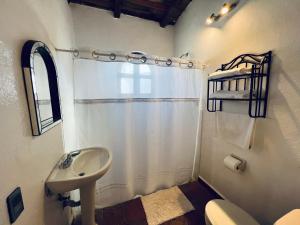 a bathroom with a sink and a shower curtain at Hotel Parador Vernal in Bernal