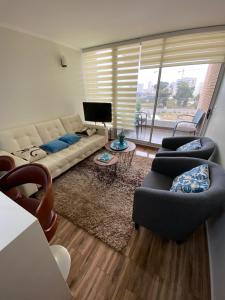 コンコンにあるDepartamento en Bosques de Montemarのリビングルーム(ソファ、椅子、テレビ付)