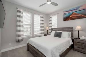 a white bedroom with a bed and a ceiling fan at Luxury Oasis! in Denver