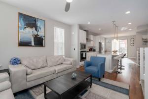 a living room with a couch and a table and a kitchen at Luxury Oasis! in Denver