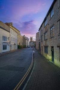 an empty street in an old town with buildings at Spacious apartment in 18th Century building, town centre with Smart TV in Cirencester