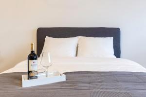 uma garrafa de vinho e um copo de vinho numa cama em Luxurious loft w-view walk city Center Delft New XL Apartment em Delft