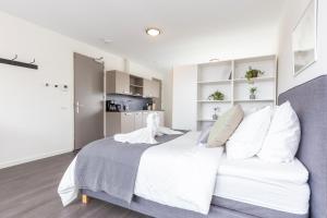 Luxurious loft w-view walk city Center Delft New XL Apartment في ديلفت: غرفة نوم بسرير ابيض كبير مع مخدات بيضاء