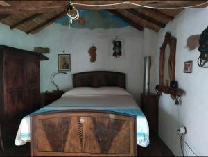 ein Schlafzimmer mit einem Holzbett in einem Zimmer in der Unterkunft Sa domu 'eccia in Urzulei