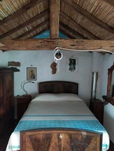 a bedroom with a bed in a room with wooden ceilings at Sa domu 'eccia in Urzulei
