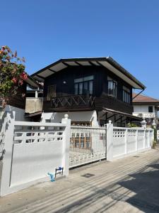 a white fence in front of a house with a house at Cozy villa in Chiangmai old town in Chiang Mai