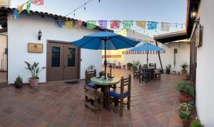 um pátio com uma mesa, cadeiras e um guarda-sol em Hacienda El Galeon em Ensenada