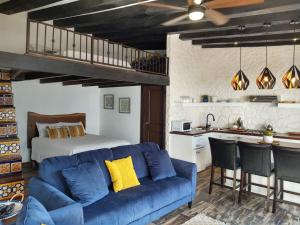 a living room with a blue couch and a bed at Hacienda El Galeon in Ensenada
