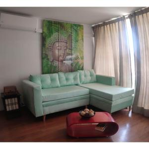 una sala de estar con un sofá verde y una estatua en Apartment located in midtown en Santiago