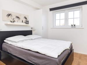 Holiday home Bogense XXXVIII في بوجنسي: غرفة نوم بسرير كبير مع شراشف بيضاء