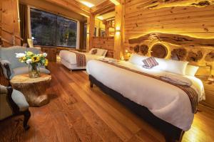 um quarto com 2 camas num chalé de madeira em CASA RAIZ Handmade House Luxury Stay em Calca