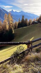 einen Holzzaun auf einem Hügel mit Bergen in der Unterkunft Chalet OG Harfe in Davos