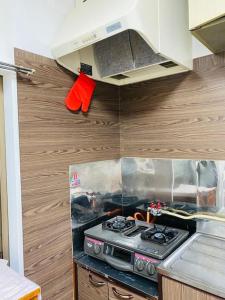 cocina con fogones y armarios de madera en 湘南の丘のヴィラーTatami Room, en Fujisawa
