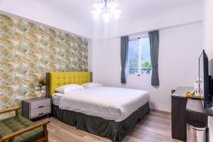 a bedroom with a bed with a yellow headboard at Bisck Hotel & Resort in Puli