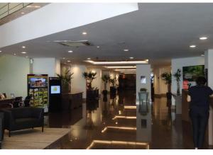 a person walking down a hallway in a building at APART HOTEL SENSE II - Localizado em Hotel in Manaus