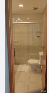 uma casa de banho com um WC e uma cabina de duche em vidro. em APART HOTEL SENSE II - Localizado em Hotel em Manaus