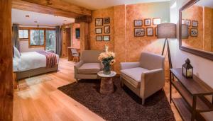 CalcaにあるCASA RAIZ Handmade House Luxury Stayのベッドルーム1室(ベッド1台、椅子2脚、テーブル付)
