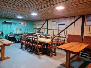comedor con mesas y sillas de madera en Refugio de Montaña Sollipulli, Lodge Nevados de, en Melipeuco