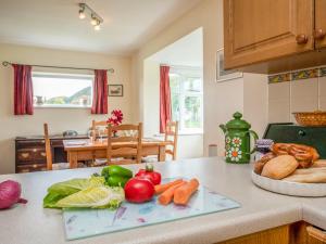 a kitchen counter with vegetables on a counter top at Bwthyn at Brynhyfryd in Pwllheli